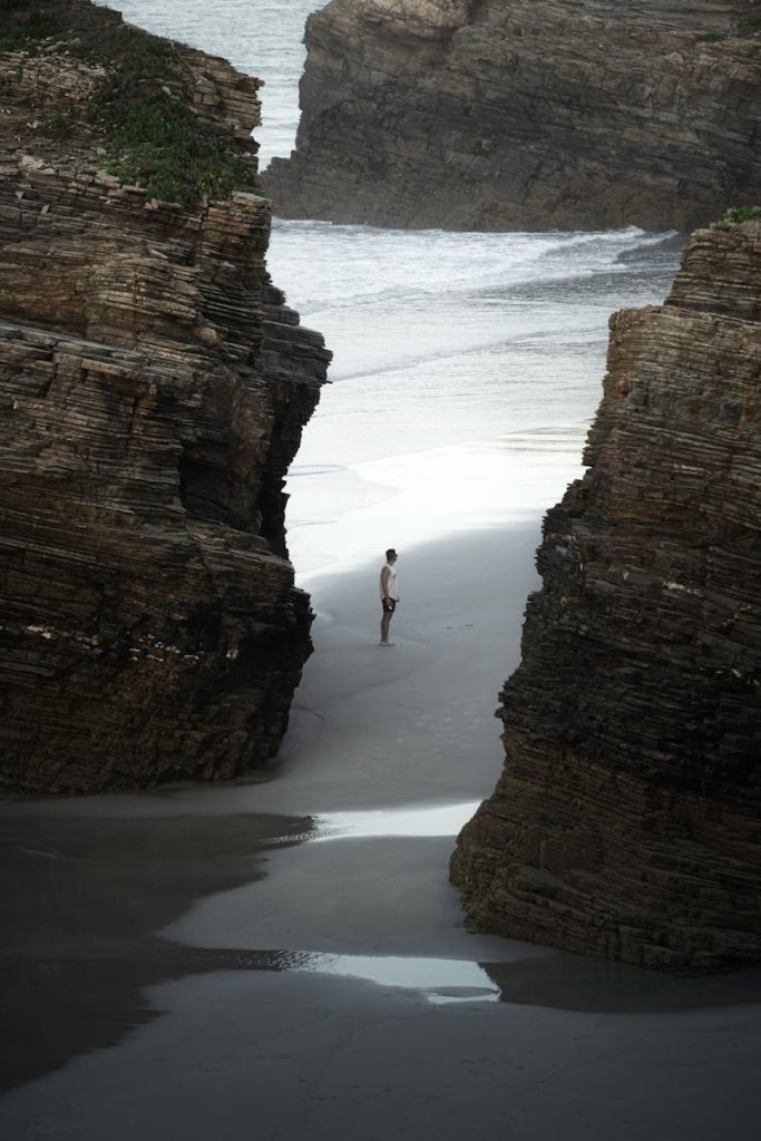 Tourist Among the Rocks on the As Catedrais Beach in Spain